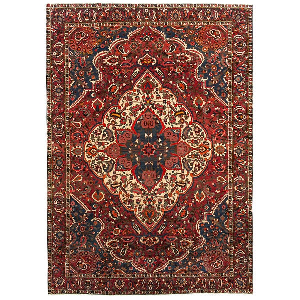 Orientteppich zeigt ein symmetrisches, florales Muster mit rot-blau-beigem Farbschema auf hellem Grund.