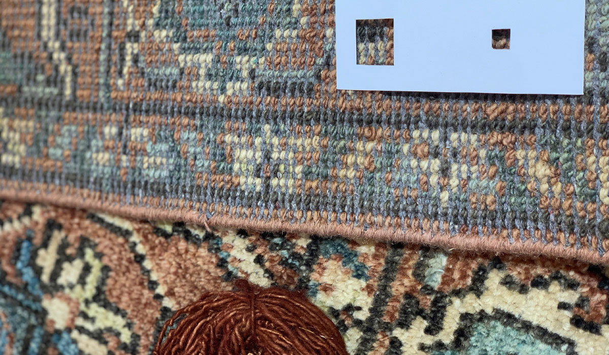 Teppich mit farbigem Muster zeigt zwei quadratische Ausschnitte auf einer weißen Karte.