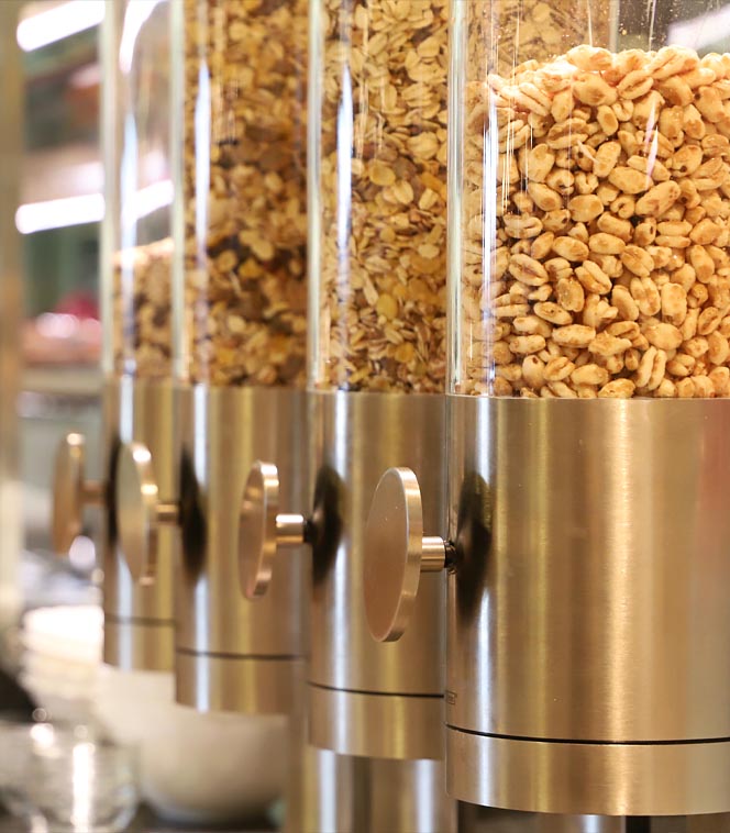Getreidezylinder geben Müsli in einem Buffetbereich aus.