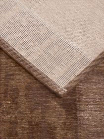 Zwei Teppiche liegen übereinander, einer beige mit Streifen, einer braun strukturiert.