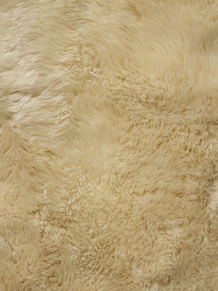 Beige flauschige Oberfläche mit unterschiedlicher Struktur und Textur, Nahaufnahme.