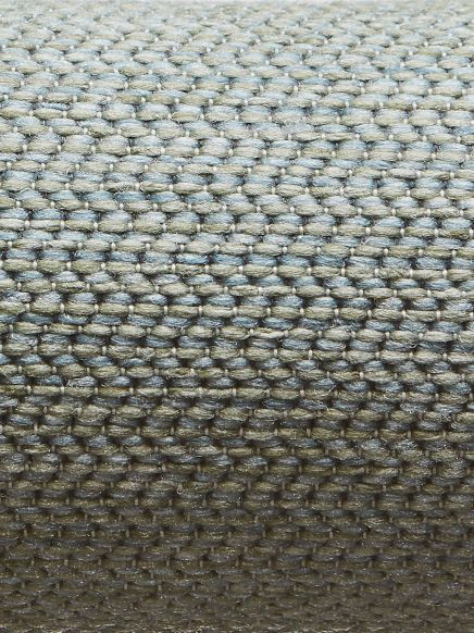 Nahaufnahme eines grob gewebten Stoffs in hellbeiger Farbe mit wiederholendem Muster