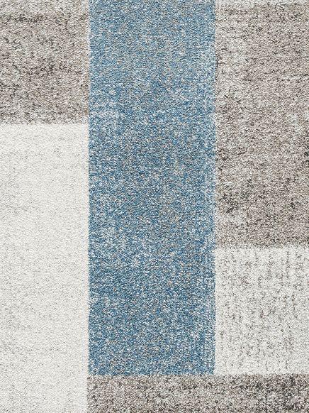 Mehrfarbiger Teppich mit blauem, beigem und weißem Rechteckmuster auf Boden.