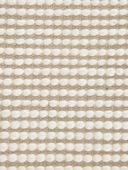 Weiße, regelmäßige, ovale Textur knüpft dicht, Hintergrund ist beige und gewebt.
