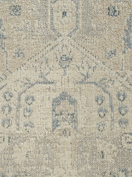 Teppich zeigt abstraktes, verblasstes Muster in Beige- und Blautönen, Nahaufnahme der Textur.