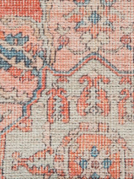 Teppich mit floralem Muster in Orange, Blau und Beige, Nahaufnahme der Webstruktur.