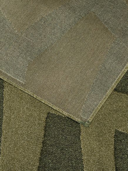 Zwei überlappende Teppiche mit geometrischen Mustern in grünen und braunen Tönen.