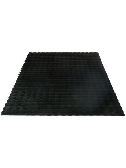 Schwarze Matte mit strukturierter, gewellter Oberfläche auf weißem Hintergrund.