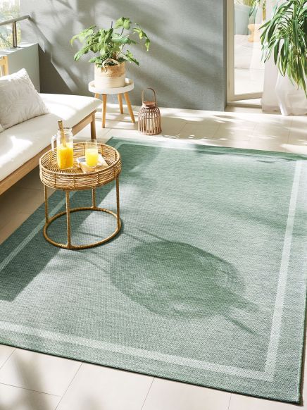 Teppich liegt auf gefliestem Boden neben einem Sofa und Tisch mit Orangensaft, Pflanzen im Hintergrund