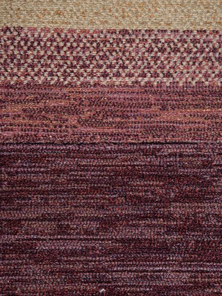 Mehrfarbiger Teppich mit rostroten, braunen und beigen Querstreifen und Punktmustern.