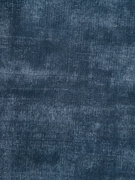 Blauer Teppich zeigt unregelmäßige, strukturierte Muster auf samtiger Oberfläche.