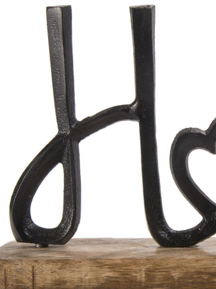 Schwarze Metallbuchstaben "H" und "L" stehen auf einem Holzbalken vor weißem Hintergrund.