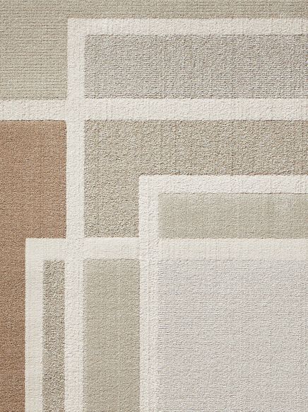 Teppich zeigt geometrisches Rechteckmuster in Beige-, Braun- und Grautönen auf hellem Hintergrund.