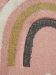 Bunter Teppich zeigt bogenförmige Muster in Rosa, Schwarz, Gelb und Weiß.