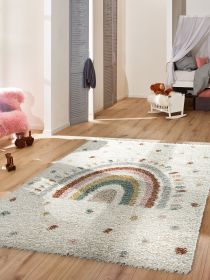 Kinderteppich zeigt mehrfarbigen Regenbogen auf hellem Boden in hellem Zimmer mit Spielzeug.