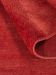 Roter Teppich wird an einer Ecke hochgeklappt, zeigt Rückseite und Oberfläche.