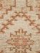 Nahaufnahme eines Teppichs mit gemusterten beige-rosa-braunen Webmustern und grober Textur.