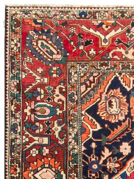Handgeknüpfter Teppich zeigt florales Muster in Rot, Blau und Orange in Nahaufnahme.
