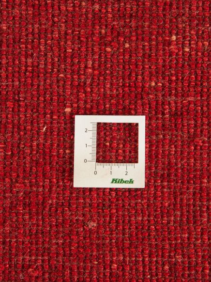 Maßlinie mit Skala zeigt Gewebestruktur auf rotem Textil mit dichter Musterung. Text: Kibek