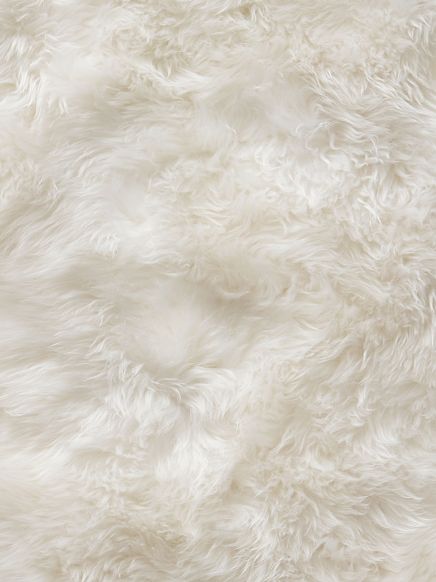Weiches, langfloriges Fell mit unregelmäßiger Struktur und hellem Farbton.