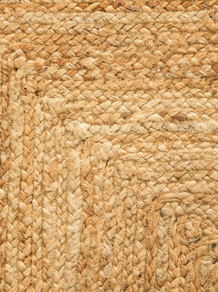 Geflechtener Teppich mit eckigem Muster aus Naturfasern, Nahaufnahme in hellem Braun.