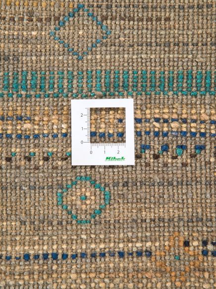 Quadratisches Maßblatt misst Teppich mit blau-grünen Mustern auf beigem Hintergrund.