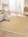 Beiger Teppich liegt auf Holzboden, daneben Sofa mit Decke, Tisch, Lampe und Sideboard im hellen Wohnzimmer.