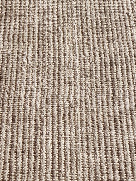 Nahaufnahme von Teppich mit grauen und beigen Linien in Indoor-Umgebung.