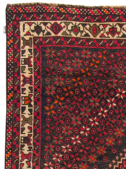 Teppich zeigt geometrisches Muster mit roten, weißen und schwarzen Formen in Rahmen, Nahaufnahme.