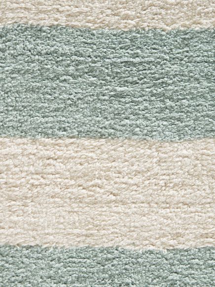 Textil mit flauschiger Struktur zeigt Streifenmuster in Grün und Cremefarben auf hellen Hintergrund.