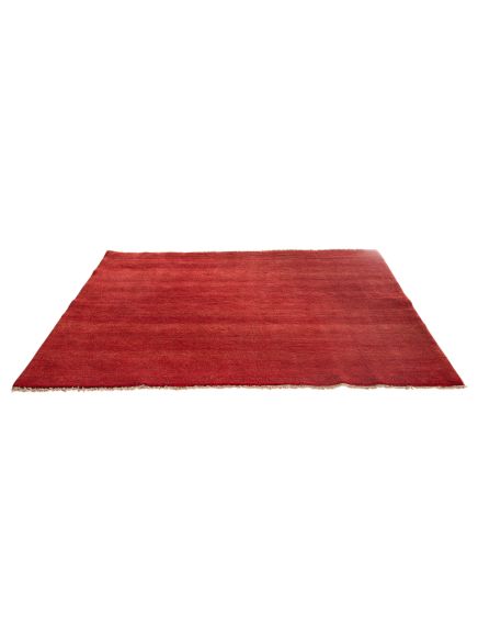Roter Teppich liegt flach auf weißem Hintergrund, Kanten leicht ausgefranst.