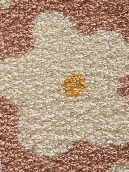 Florales Teppichmuster mit cremefarbenen Blütenblättern und gelbem Blütenstempel auf rosa Grund