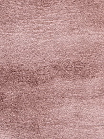 Rosa flauschiger Teppich mit unregelmäßiger, weicher Struktur, Nahaufnahme.