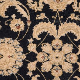 Teppich mit beigen floralen Ornamenten auf schwarzem Hintergrund in Nahaufnahme.