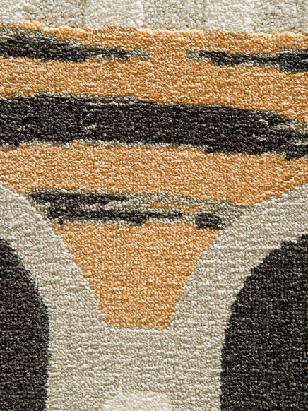 Nahaufnahme eines Teppichs mit abstraktem Muster in Beige, Schwarz und Weiß.