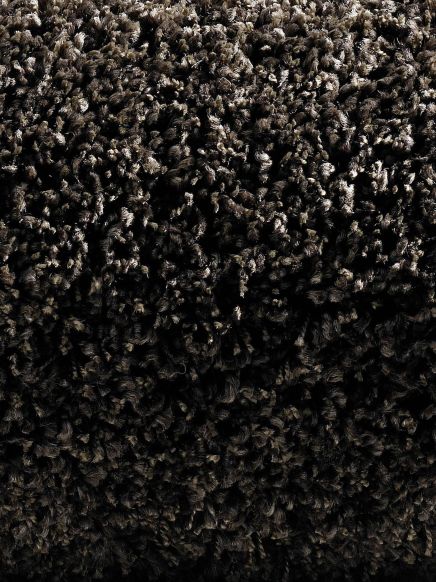 Dichtes, dunkles, flauschiges Teppichmaterial mit unregelmäßiger Struktur und Textur.