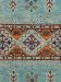 Teppich zeigt geometrische Muster und farbige Ornamente in Blau, Orange und Rot auf Textilfläche.