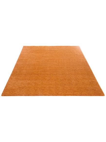 Rechteckiger, einfarbiger Teppich in Orange liegt flach auf weißem Hintergrund.