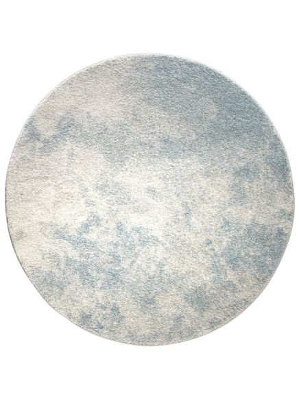 Runder Teppich liegt flach, zeigt abstraktes Muster in hellblau und beige auf weißem Hintergrund.