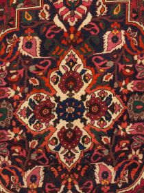 Orientalischer Teppich mit floralem Muster in Rot-, Blau-, Rosa- und Grüntönen in symmetrischem Design.