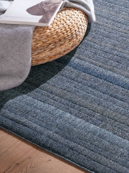 Zeitschrift liegt auf einem grauen Tuch, das einen geflochtenen runden Korb auf einem blauen Teppich bedeckt. Text: Dachshunds Short and Long.