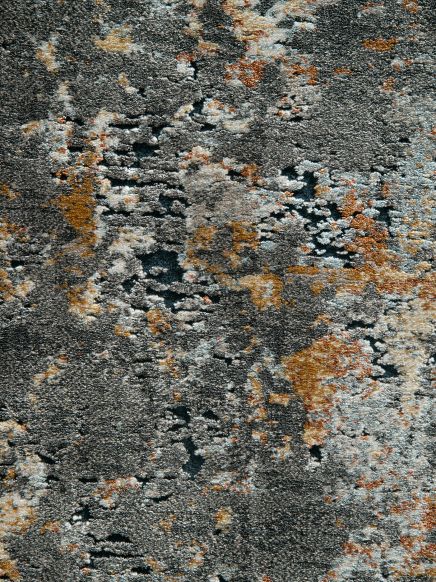 Textur einer grauen Oberfläche mit unregelmäßigen orangefarbenen und weißen Flecken, Nahaufnahme.