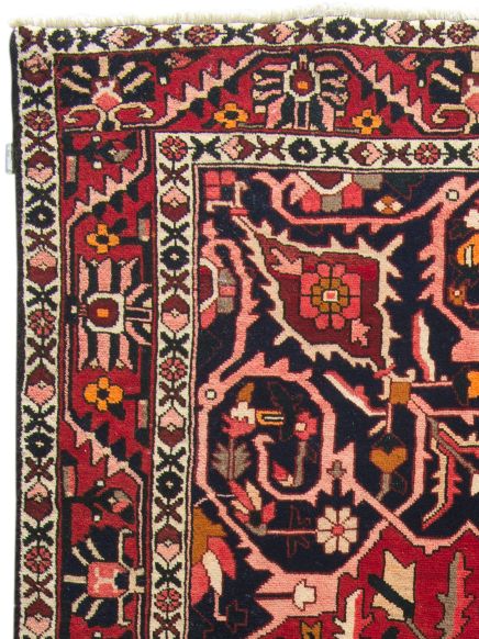 Eckiger Teppich mit floralen und geometrischen Mustern in Rot, Blau, Schwarz und Beige.