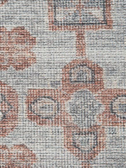 Teppich mit floralem Muster in grauen und roten Farbtönen in Nahaufnahme.