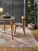 Stuhl steht neben Tisch mit Karaffe und Gläsern, Zimmer mit Pflanze und Teppichboden.
