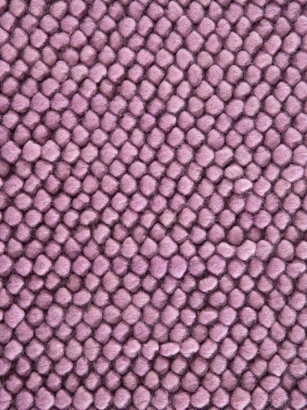 Nahaufnahme eines rosa Teppichs mit dicht gepackten, runden, weichen Fasern.