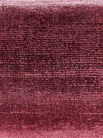 Nahaufnahme eines weinroten Stoffes mit samtiger Textur in gleichmäßiger Oberfläche