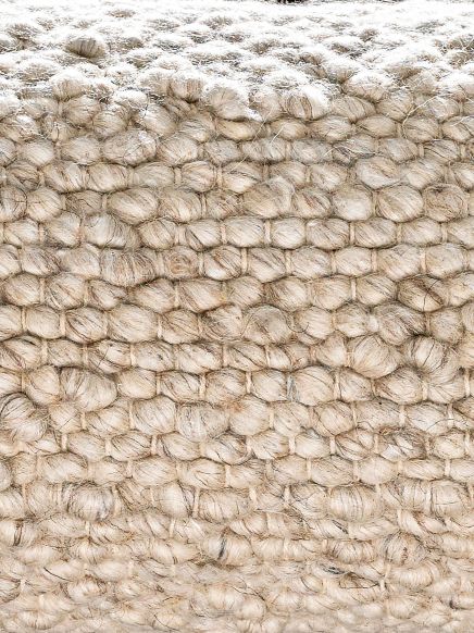 Grober, gehäkelter Stoff in Beige, dicht verwobene Textur, Nahaufnahme ohne sichtbare Umgebung