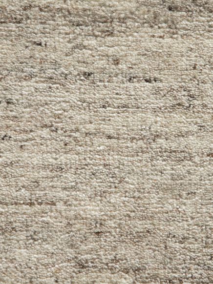 Teppich zeigt dichtes, unifarbenes, beige-graues Muster ohne erkennbare Form im Nahaufnahme-Ausschnitt.