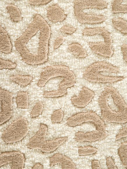 Textur mit beige-braunen Tupfen auf cremefarbenem Hintergrund, Teppichmuster nah aufgenommen.